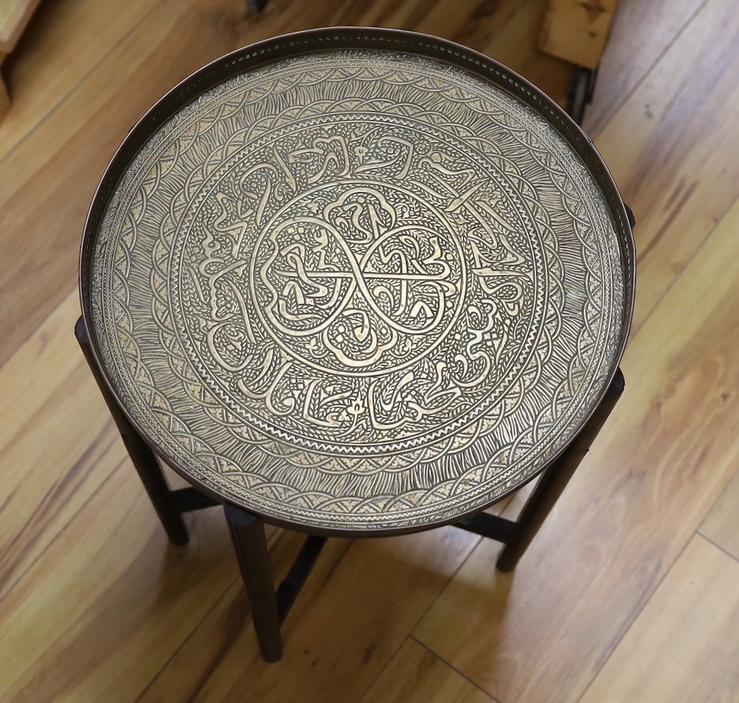 Benares brass folding table on wooden stand, 52cm tall, together with a three-footed lion pawed coal bucket and cover